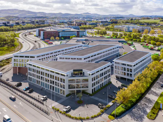 3D-visualisering av næringspark med kontorbygg, parkering og tilkomstvei